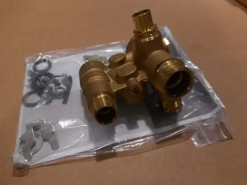 Brass Hydroblock mit mehreren Anschlüssen und Zubehörteilen in durchsichtiger Verpackung, hergestellt von Remeha.